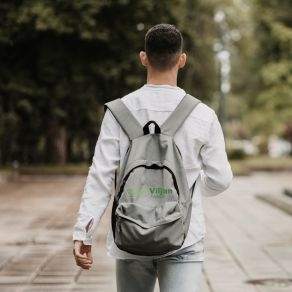 Ung man med ryggsäck promenerar